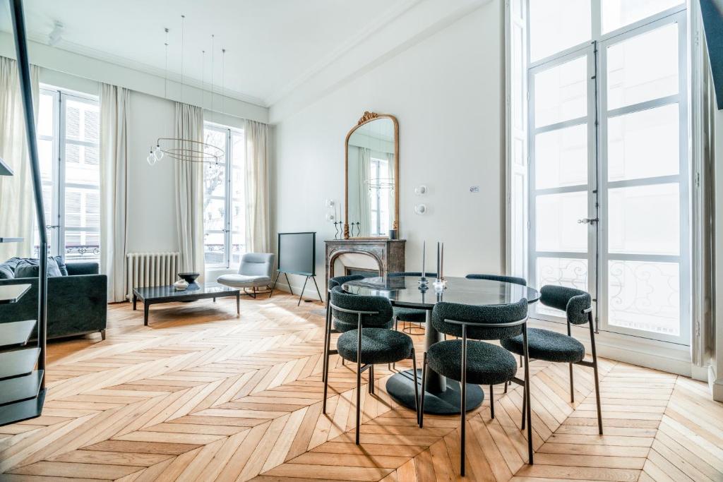 une salle à manger avec une table en verre et des tabourets dans l'établissement Luxury and Elegance Louvre - Rivoli, à Paris