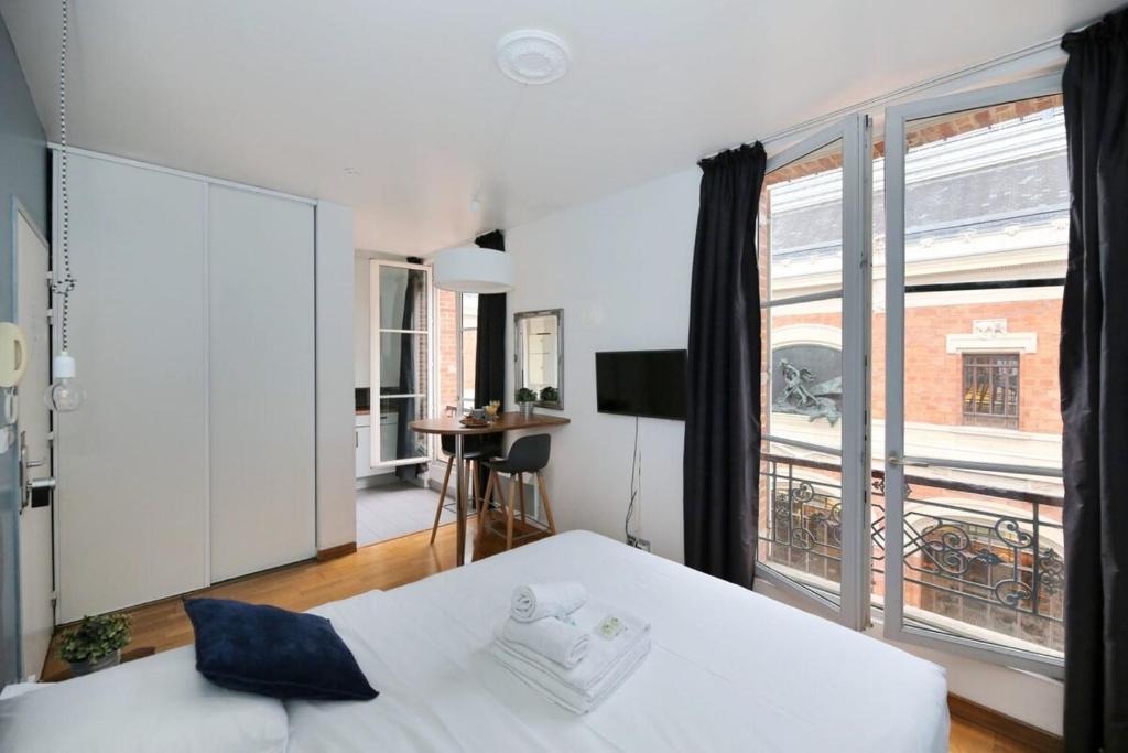 une chambre avec un lit et une grande fenêtre dans l'établissement 405 - sejour romantique dans un studio de Paris 5, à Paris