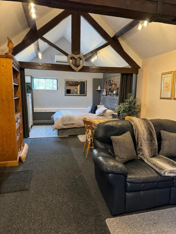 a living room with a bed and a couch at Christmas Cottage in Doveridge