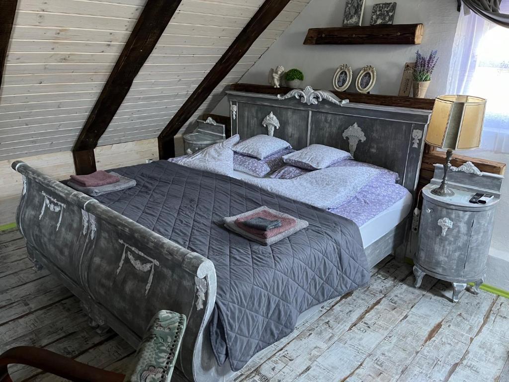 a bedroom with a large bed with purple sheets and pillows at Living Past Vendégház in Kővágóörs