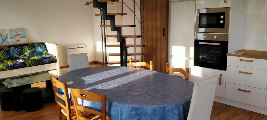 une cuisine avec une table et une salle à manger avec un canapé dans l'établissement L'évasion Littorale de Sion - Saint Hilaire de Riez, à Saint-Hilaire-de-Riez