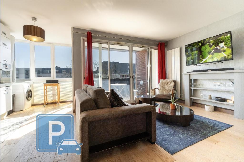 un salon avec un canapé et une télévision dans l'établissement Emplacement idéal, Garage privé, Lumineux, à Rennes