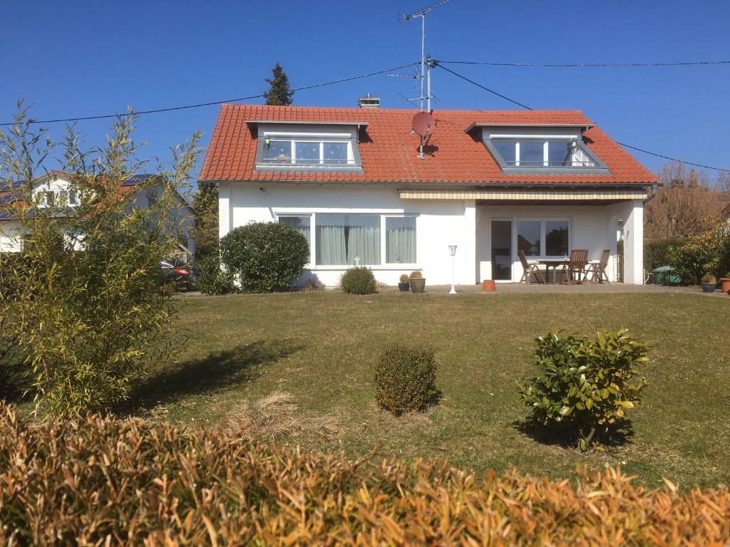 uma casa branca com um telhado vermelho e um quintal em Appartement Zahn em Bad Waldsee