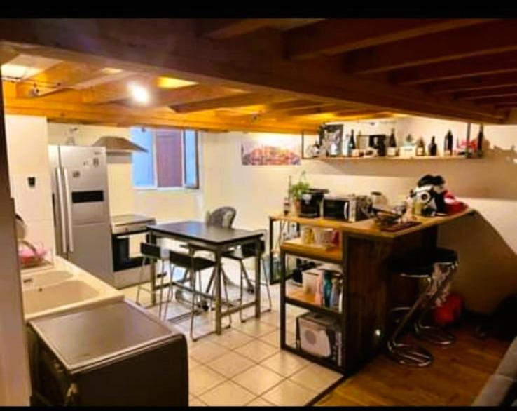 une cuisine avec un comptoir et une table à l'intérieur dans l'établissement Loft, à Caluire-et-Cuire