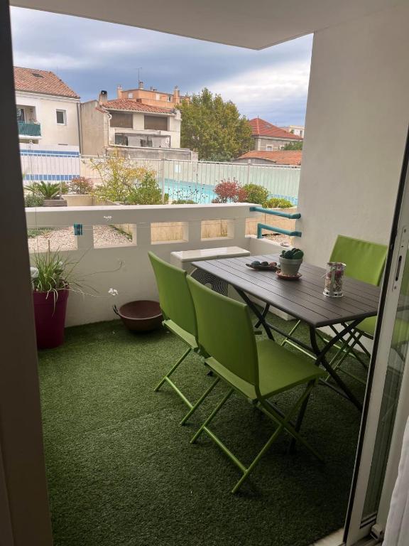 un patio avec une table et des chaises sur un balcon dans l'établissement The squadra with swimming pool, à Frontignan
