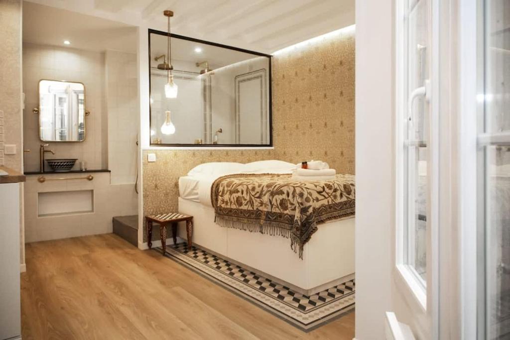 une chambre avec un lit et un miroir au mur dans l'établissement Magnifique appartement familial grand boulevard-6P, à Paris