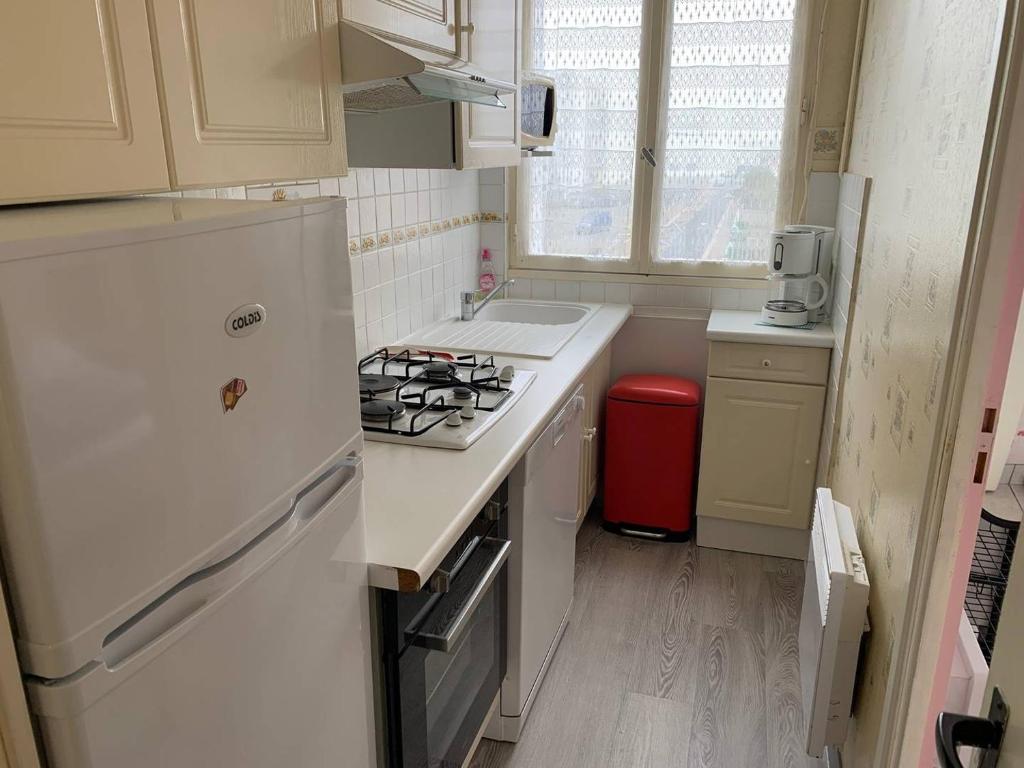 Il comprend une cuisine équipée d'une cuisinière et d'un réfrigérateur blanc. dans l'établissement Le Bel vue Montois - Saint Jean de Monts, à Plage-des-Demoiselles