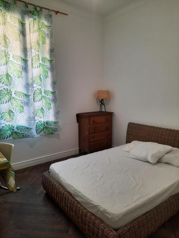 une chambre avec un lit, une commode et une fenêtre dans l'établissement Appartement près des plages, à Nice