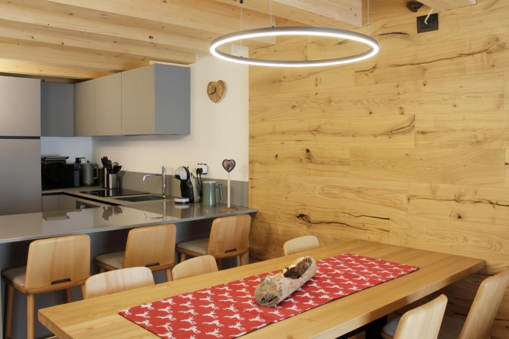 une cuisine et une salle à manger avec une table et des chaises dans l'établissement ALPINE LOFT - Residence Veronza con piscina, Dolomiti Affitti, à Cavalese