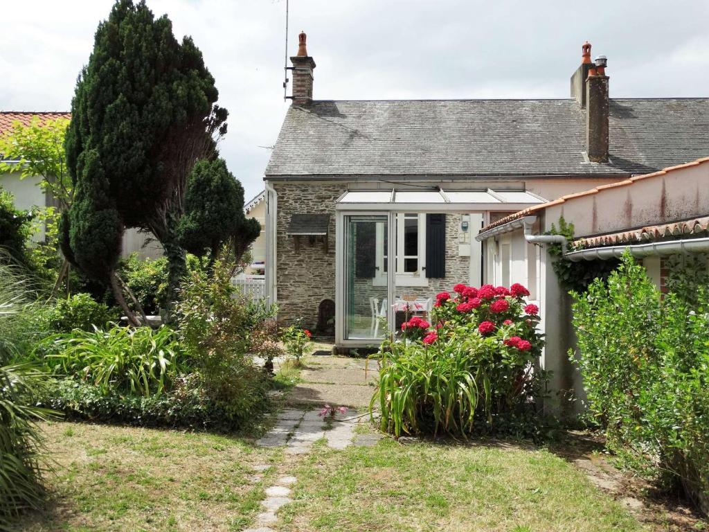 une maison avec un jardin et des fleurs devant elle dans l'établissement Hippocampe Saint Gilles croix de Vie, à Les Bussolleries