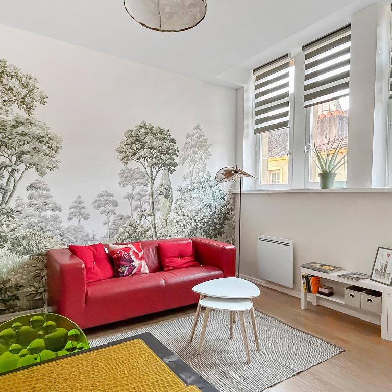 un salon avec un canapé rouge et une table dans l'établissement Lumineux & Cosy, Hyper Centre Metz, à Metz