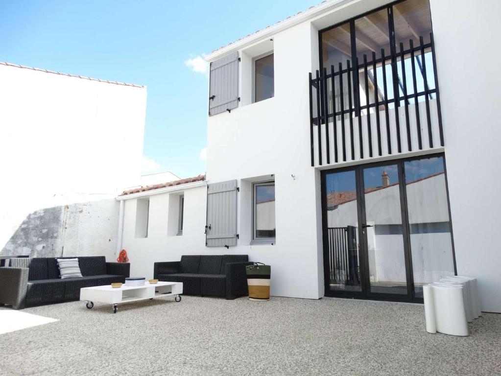 - un bâtiment blanc avec un mobilier noir devant dans l'établissement Méridien Saint Gilles Croix de Vie, à Saint-Gilles-Croix-de-Vie