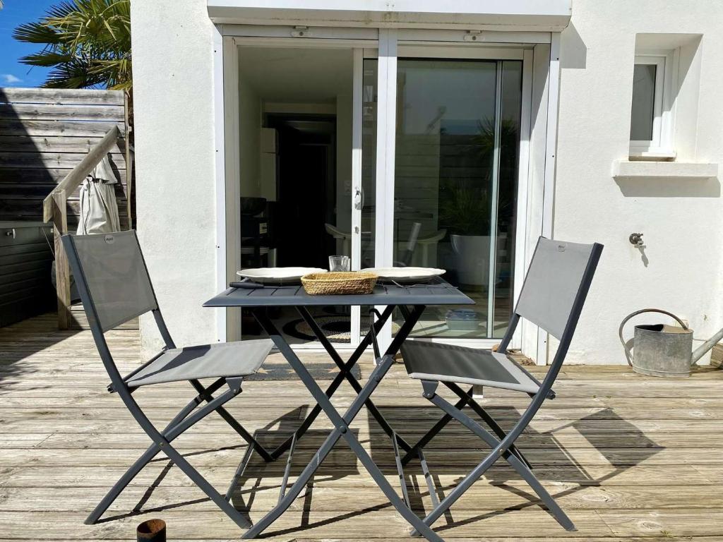 - une table de pique-nique et 2 chaises sur la terrasse dans l'établissement Dauphin Saint Gilles Croix de Vie, à Les Bussolleries