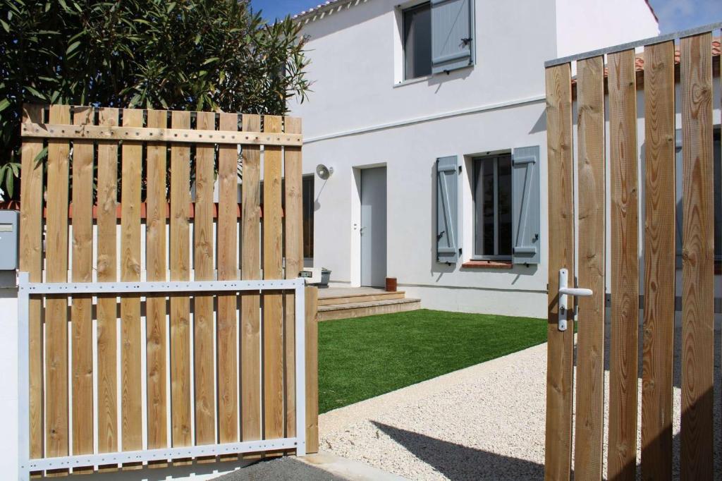 une porte en bois devant une maison dans l'établissement Géranium Saint Gilles Croix de Vie, à Les Bussolleries