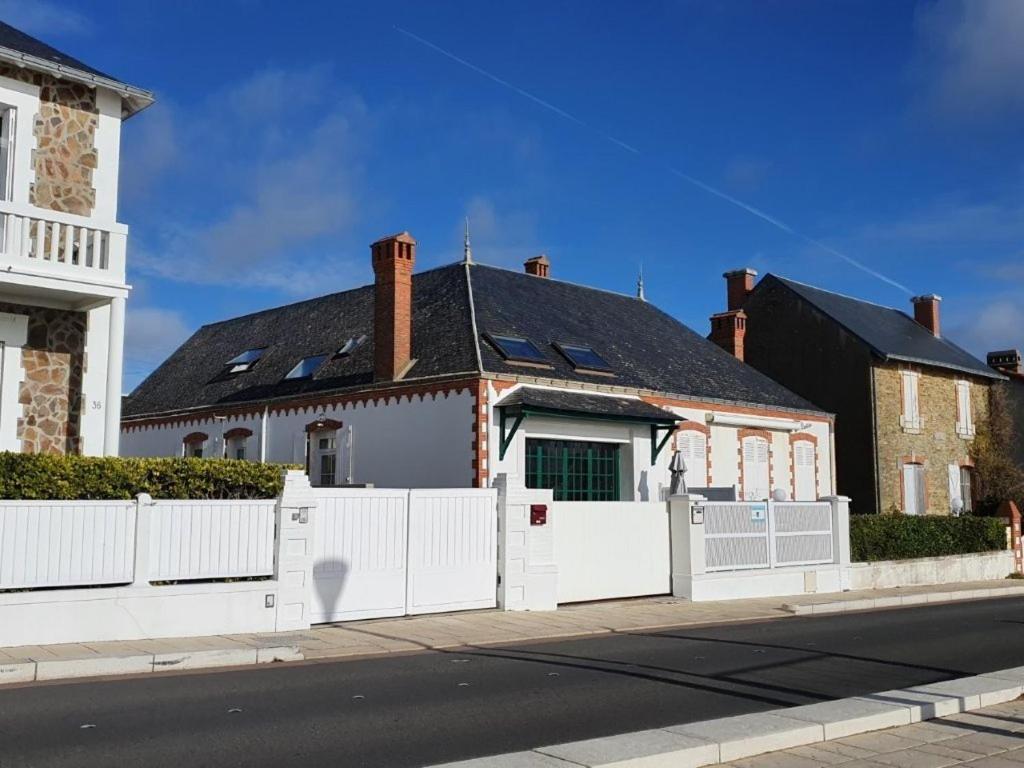 a white fence in front of a house at Le Mistral Saint Gilles Croix de Vie in Les Bussolleries