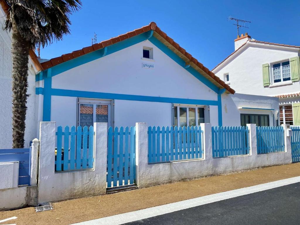 a blue and white house with a fence at Youyou Saint Gilles Croix de Vie in Les Bussolleries