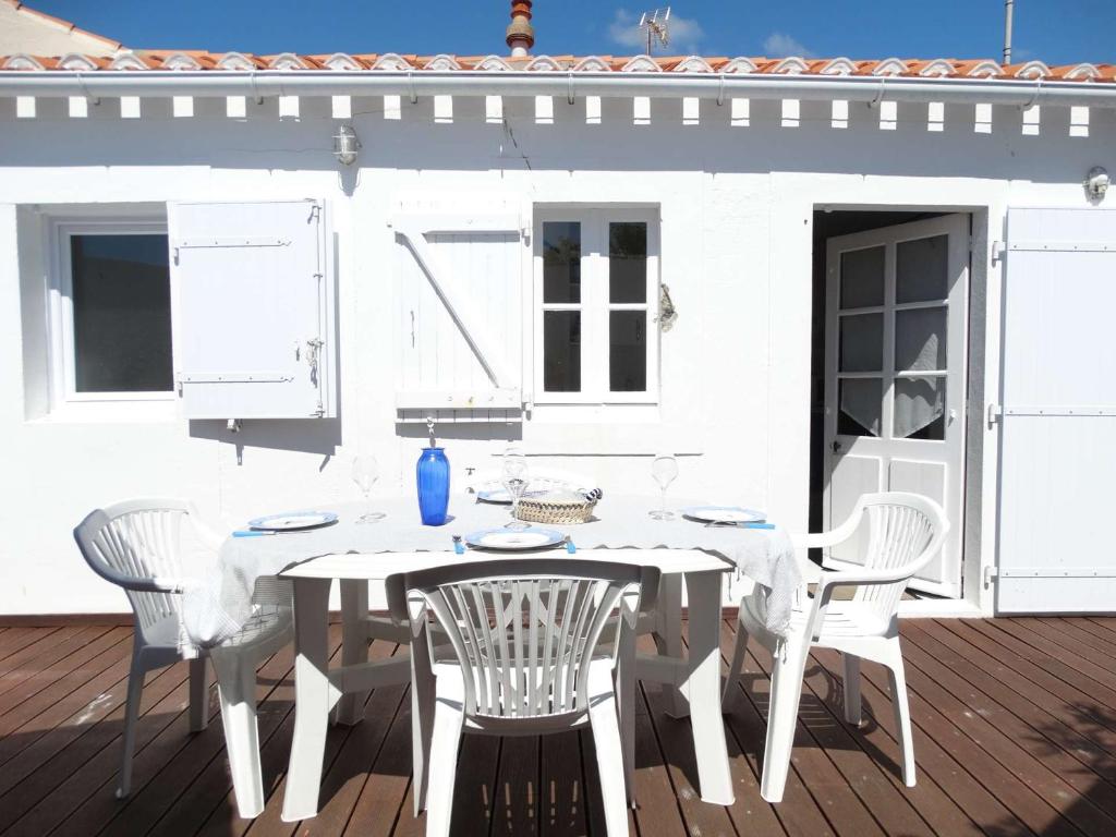 une table et des chaises blanches sur une terrasse dans l'établissement Maison Saint Gilles Croix de Vie - L'Embellie, à Saint-Gilles-Croix-de-Vie