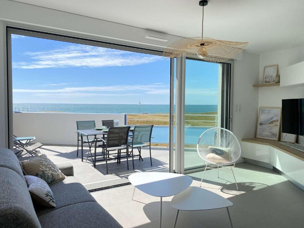 un salon avec un canapé et une vue sur l'océan dans l'établissement Evasion Saint Hilaire de Riez, à Sion-sur-lʼOcéan