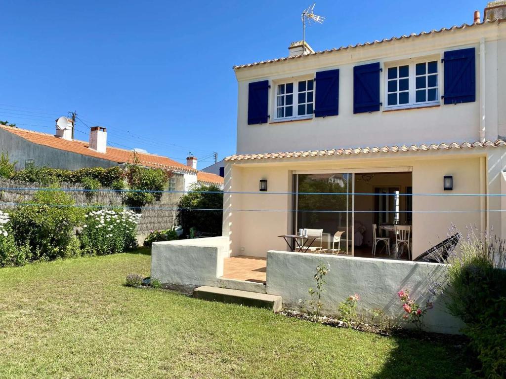 Casa blanca con ventanas azules y patio en Rivage - Saint Hilaire de Riez, en Les Bussolleries