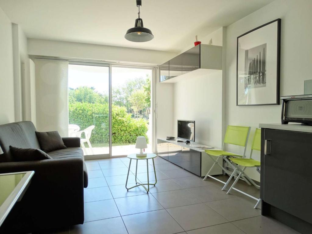 サン・ジル・クロワ・ド・ヴィにあるMatelot Saint Gilles Croix de Vieのソファとテーブルと椅子のあるリビングルーム