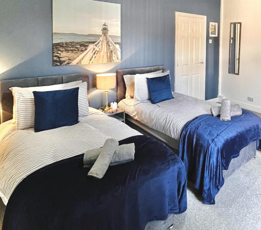 two beds in a room with blue walls at Ideal 3 bed pay-as-you-stay home in Wigan sleeps 6 in Wigan