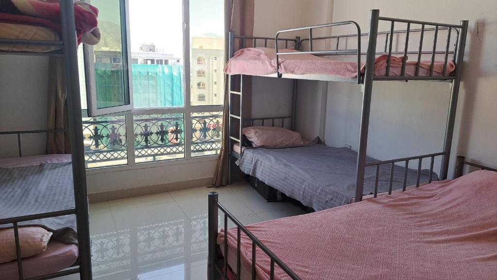 una habitación con dos literas y una ventana en New mohastel, en Mascate