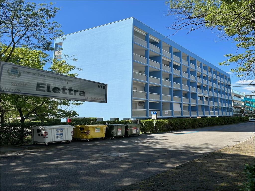 een groot wit gebouw met een bord ervoor bij Condominio Athena in Bibione