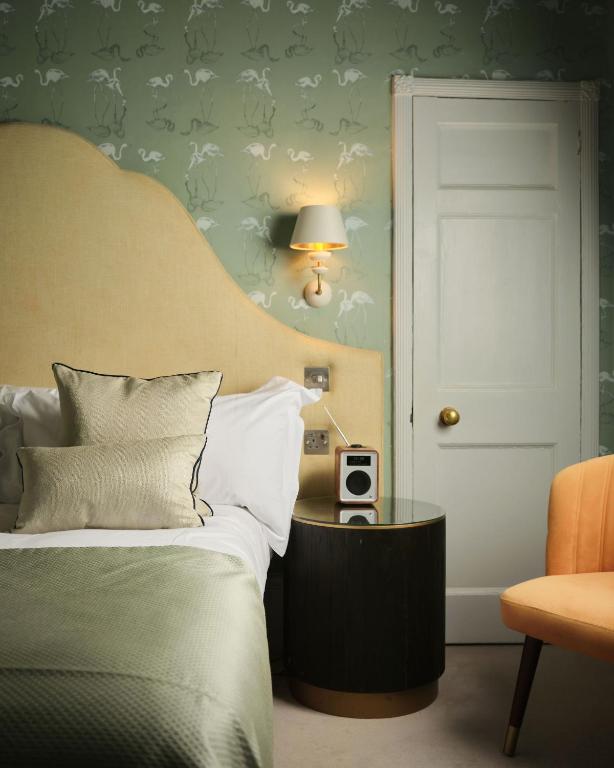 a bedroom with a bed and a table with a lamp at The Queensberry Hotel in Bath