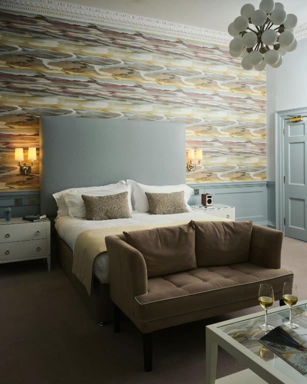 a bedroom with a large bed and a couch at The Queensberry Hotel in Bath
