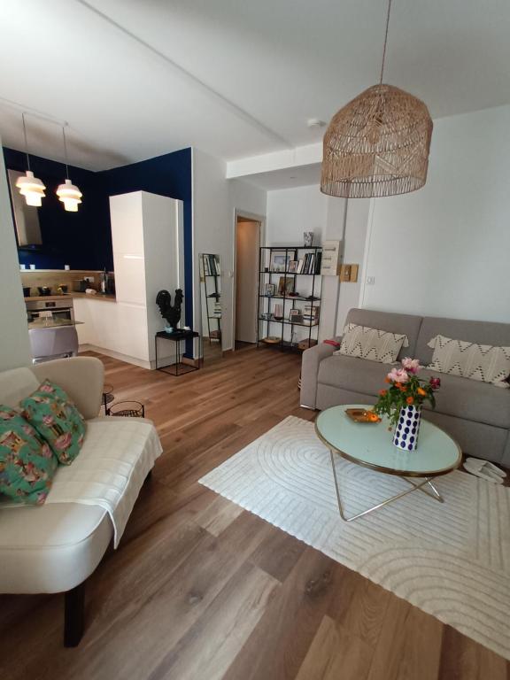 un salon avec un canapé et une table dans l'établissement Appartement T2 40 m2 rue du casino centre-ville climatisé 1 chambre balcon, à Aix-les-Bains