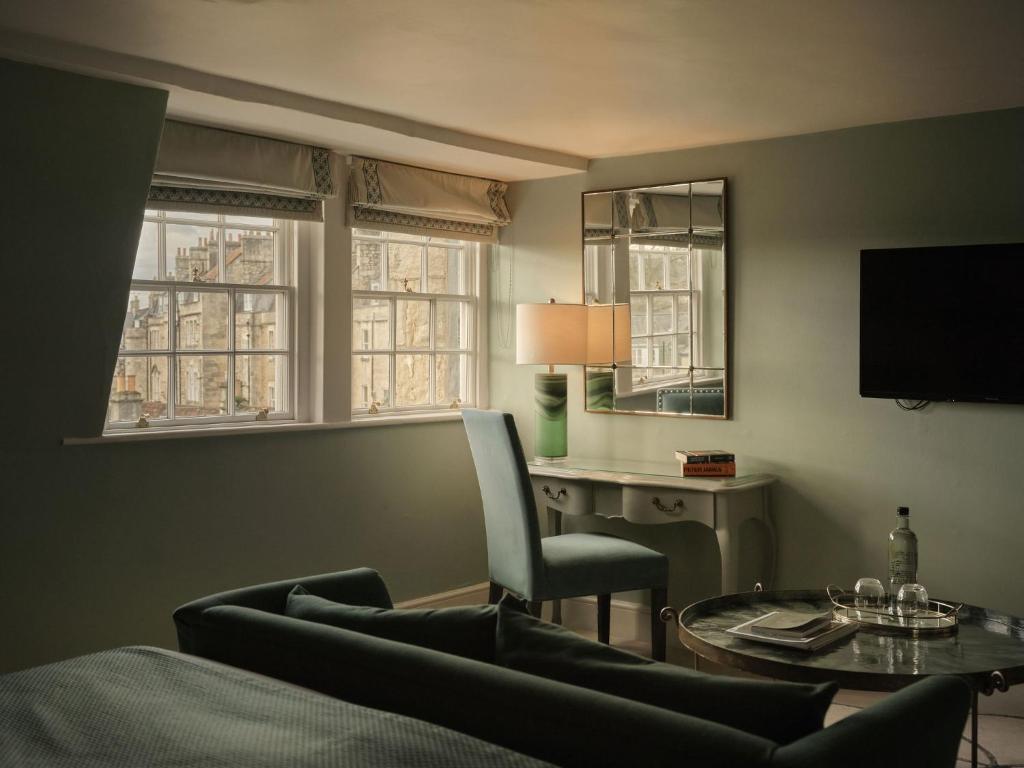 a living room with a couch and a table and a desk at The Queensberry Hotel in Bath