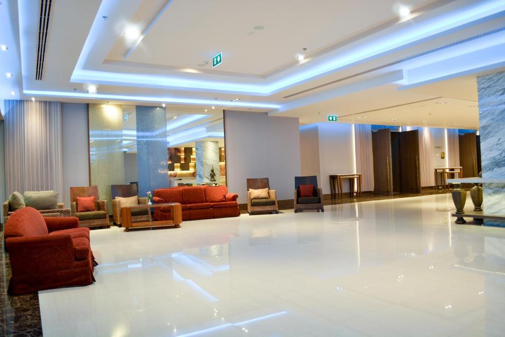 Bright hotel lobby with a broad polished floor and varied lounge seating.
