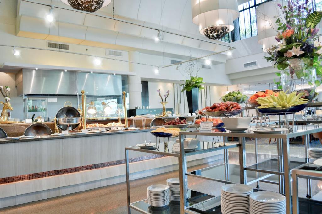 A bright buffet counter with prepared dishes and stacked plates.