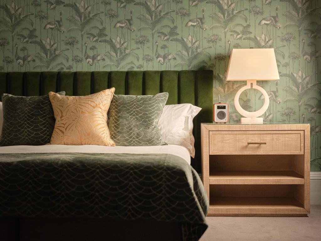a bedroom with a bed and a table with a lamp at The Queensberry Hotel in Bath