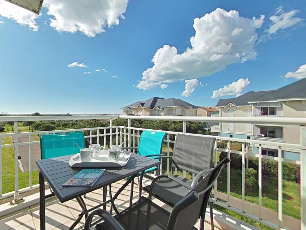 eine Terrasse mit Tisch und Stühlen auf einem Balkon in der Unterkunft Appartement 3 pièces avec balcon à 700m de la plage - 6 couchages, garage, classé 3 étoiles - FR-1-224-710 in Saint-Gilles-Croix-de-Vie