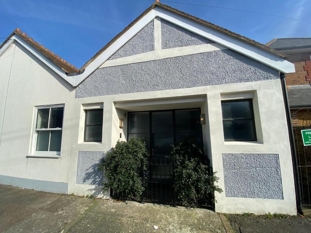 a white house with a large door on a street at The Motor House in Worthing