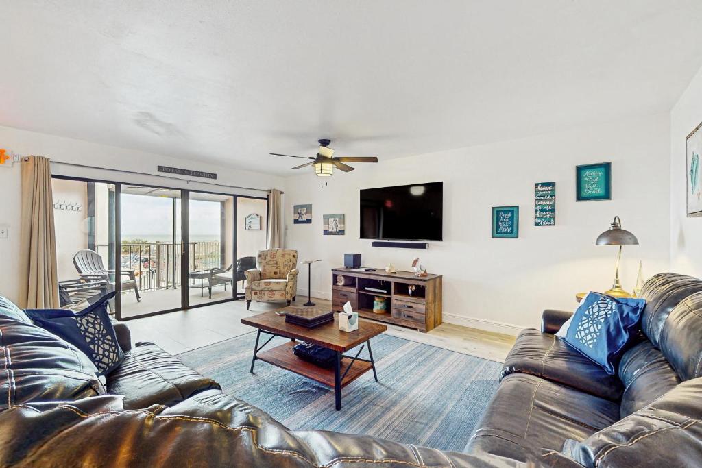 a living room with a couch and a tv at Reef Club 107 in Clearwater Beach