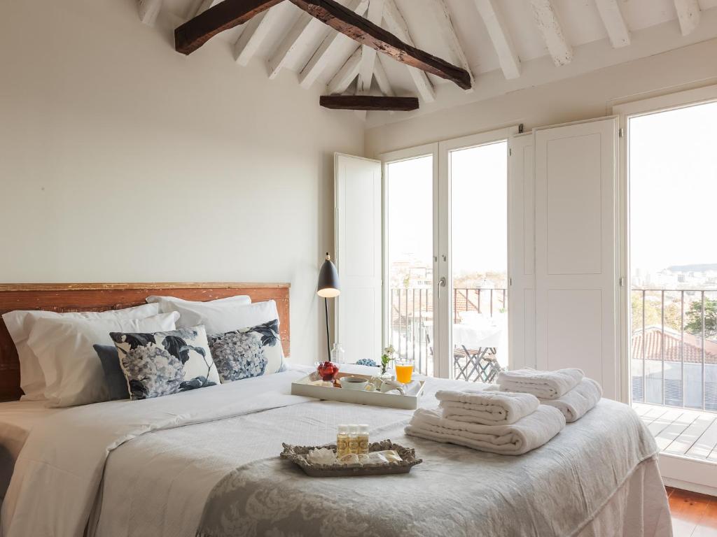 Down2Town B&B في بورتو: غرفة نوم بيضاء مع سرير كبير عليه مناشف