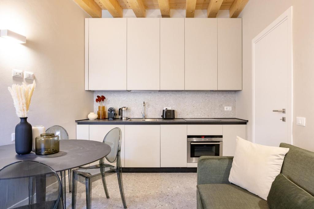 Una cocina y una sala de estar con una mesa y un sofá. en PALAZZO CIVIDALE Suite in the City Center, en Vicenza