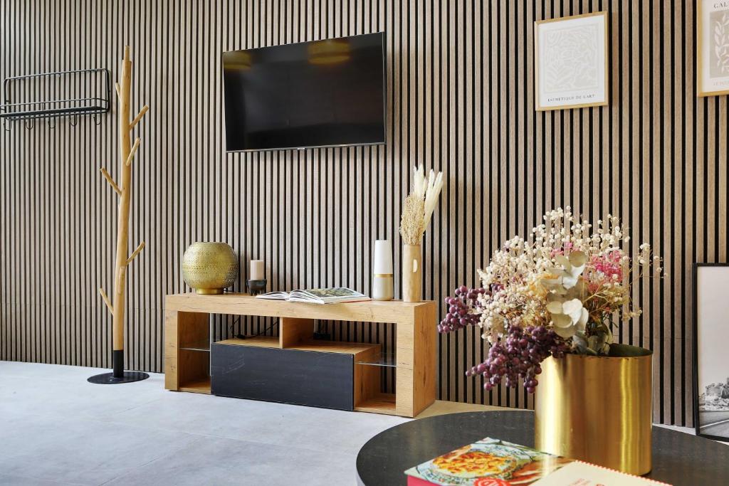 - un salon avec une télévision et une table fleurie dans l'établissement Wonderful apartment - 1BR 5P - Sacré Cœur Ramey, à Paris