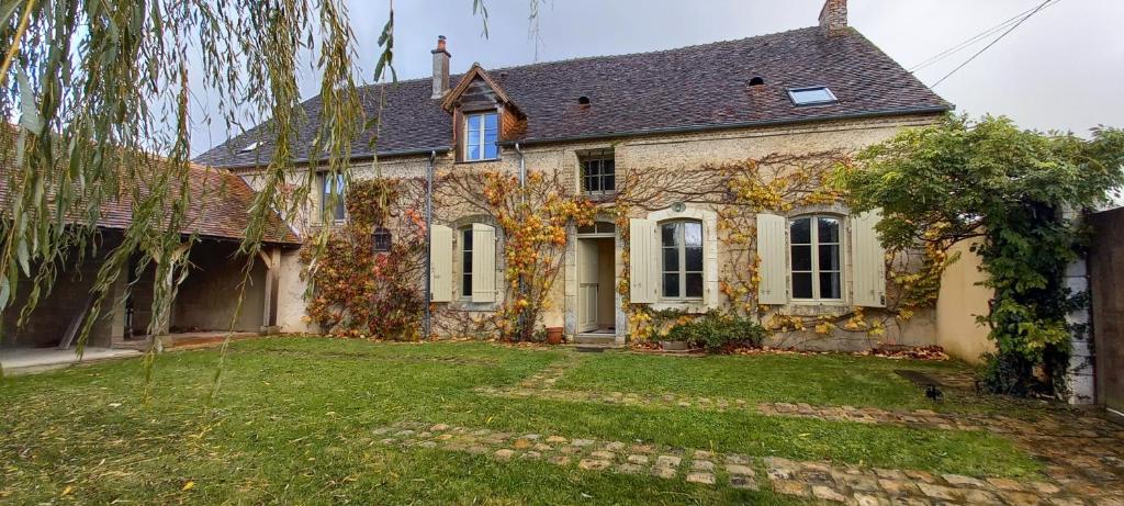 une maison en pierre avec une cour devant elle dans l'établissement La Némerie, à Vivoin