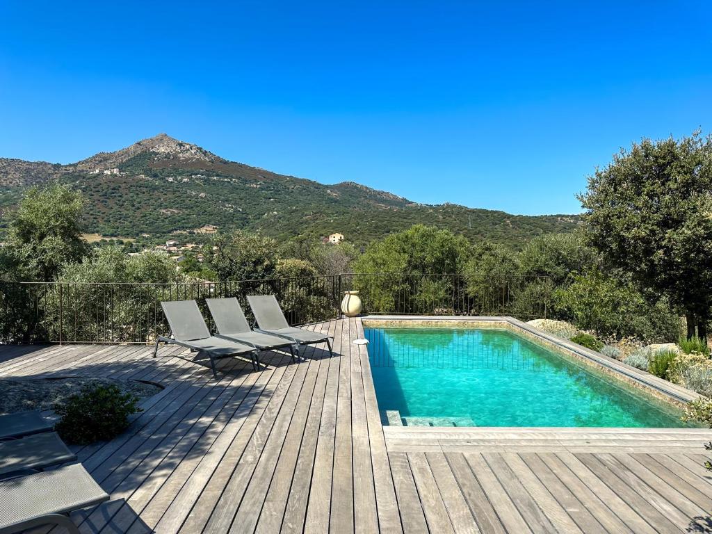 a swimming pool with two chairs and a wooden deck at Domaine Villas Celia in Monticello