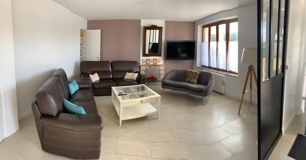 un salon avec un canapé et une table dans l'établissement maison campagne et mer 10 personnes, à Surville