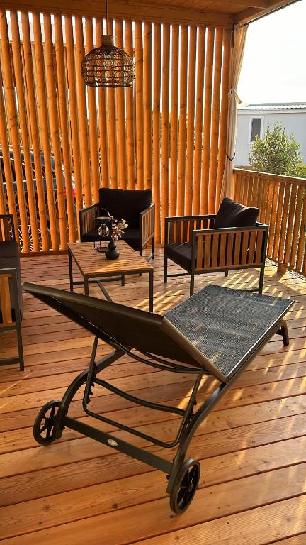 a cart on a wooden deck with chairs and tables at Mobile home Max in Drage