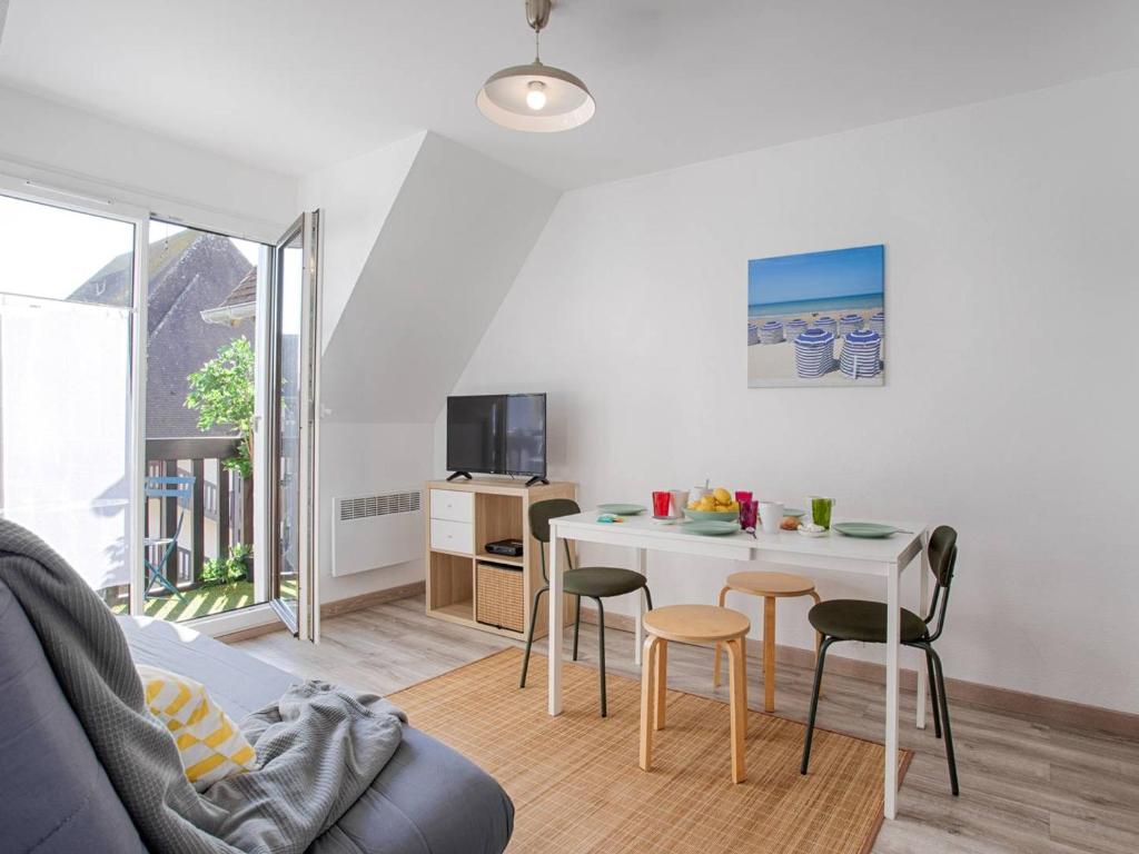 un salon avec une table et des chaises blanches dans l'établissement Appartement à Deux Pas de la Plage de Cabourg, Balcon, WiFi, Parking Gratuit ! - FR-1-788-29, à Cabourg