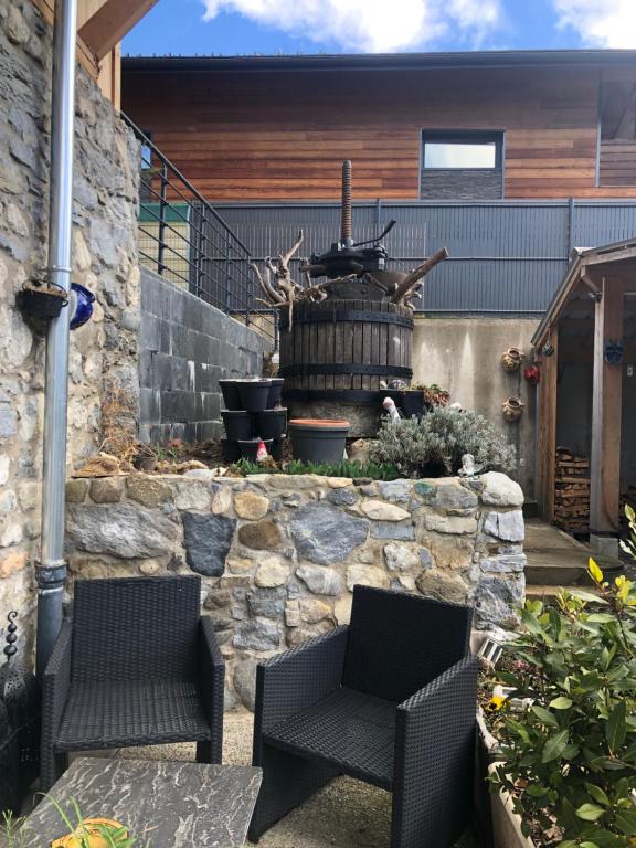 d'une terrasse avec 2 chaises et un mur en pierre. dans l'établissement Sub zéro, à Saint-Jean-de-Tholome