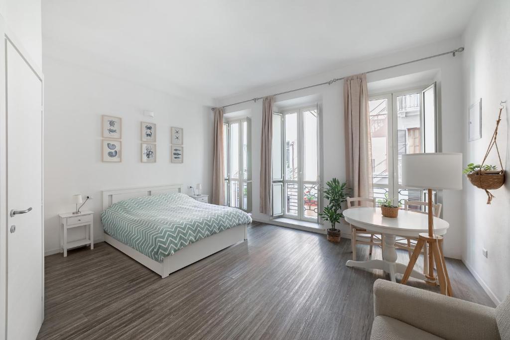 Un dormitorio blanco con una cama y una mesa. en Casa Marina Guesthouse Cagliari, en Cagliari