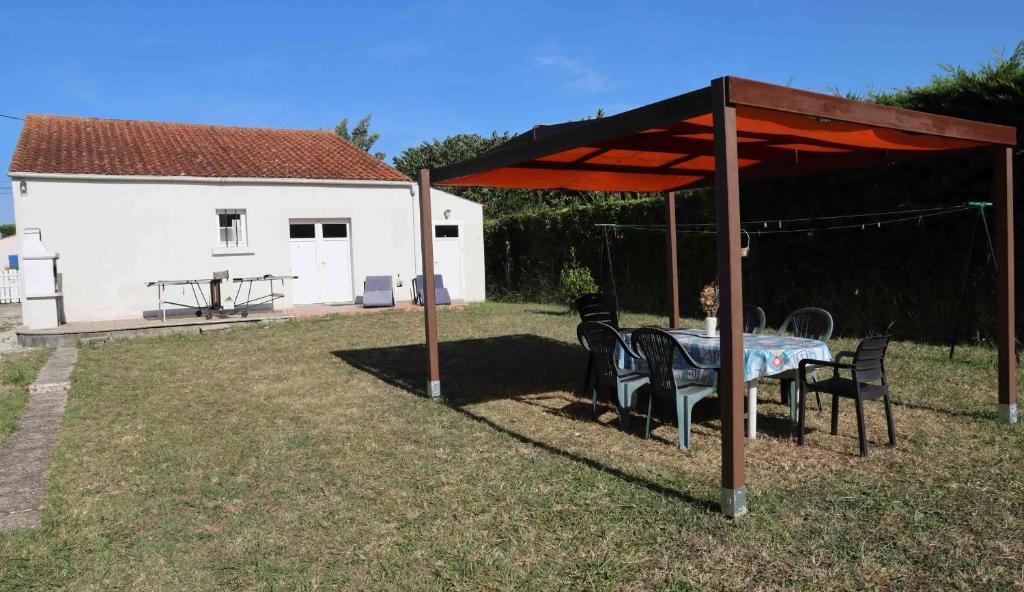 une table et des chaises sous un pavillon dans une cour dans l'établissement Maison 4 pièces - 6 couchages - Saint Georges d'Oléron SGO000-028, à Saint-Georges-dʼOléron