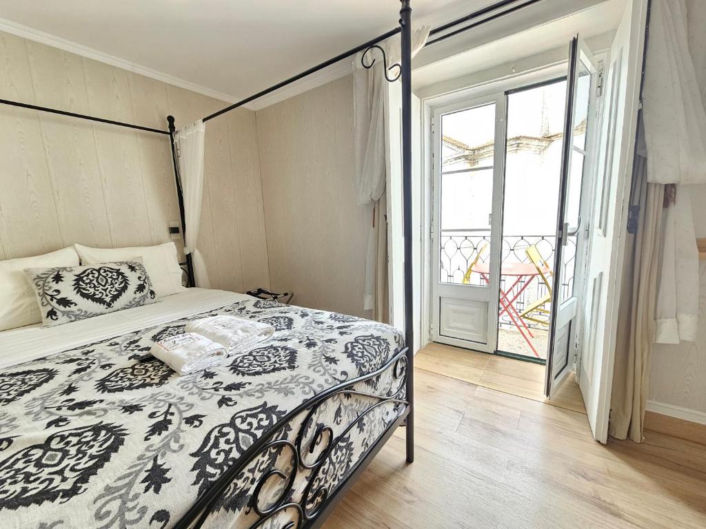 a bedroom with a bed with a black and white comforter at Charme da Graça - Guest House in Lisbon
