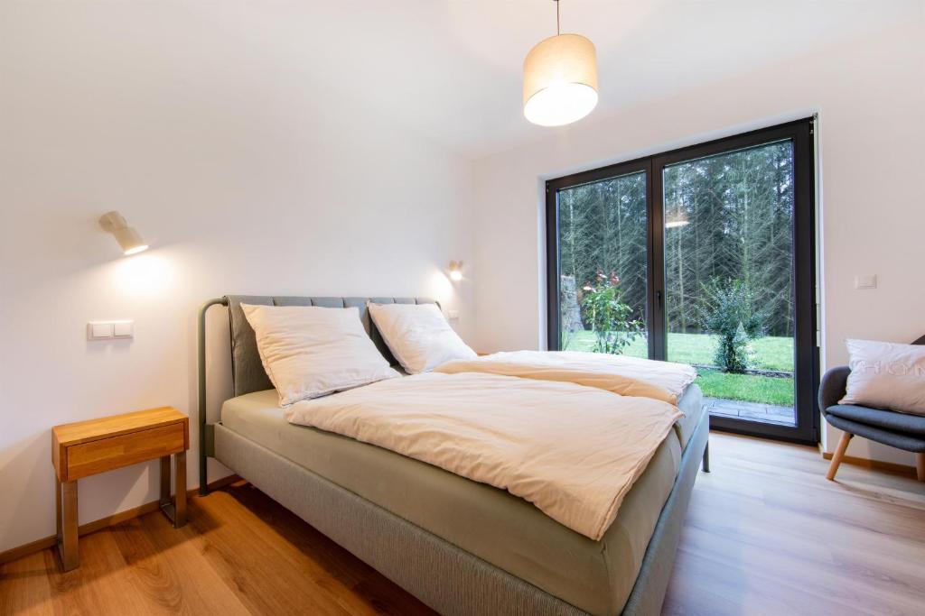 a bed in a room with a large window at NATURNEST Eifel in Daun